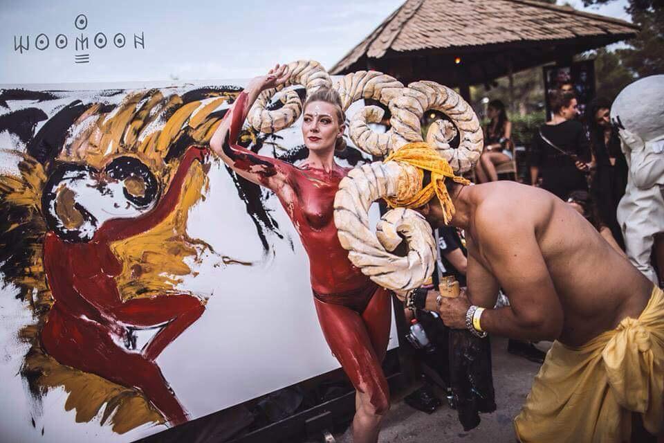 A body-painted performer and a horned headdress at the canvas, at Woomoon