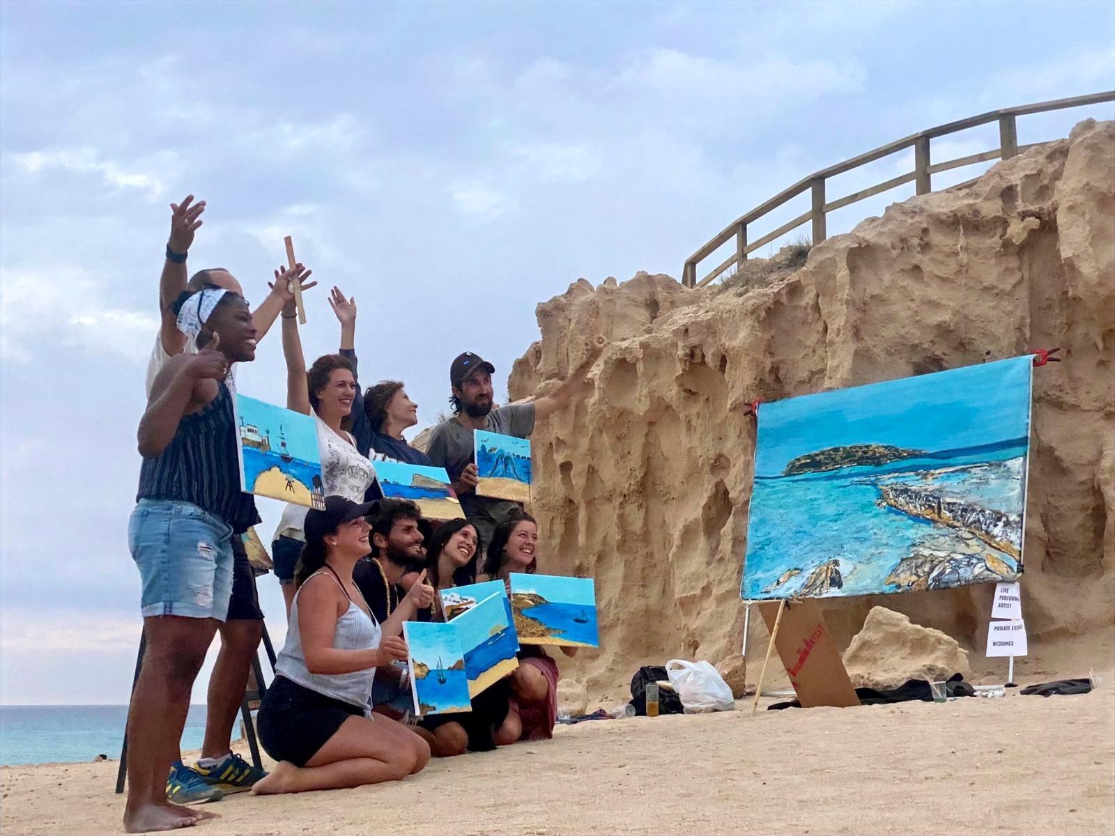 A workshop group holding up the canvases they painted