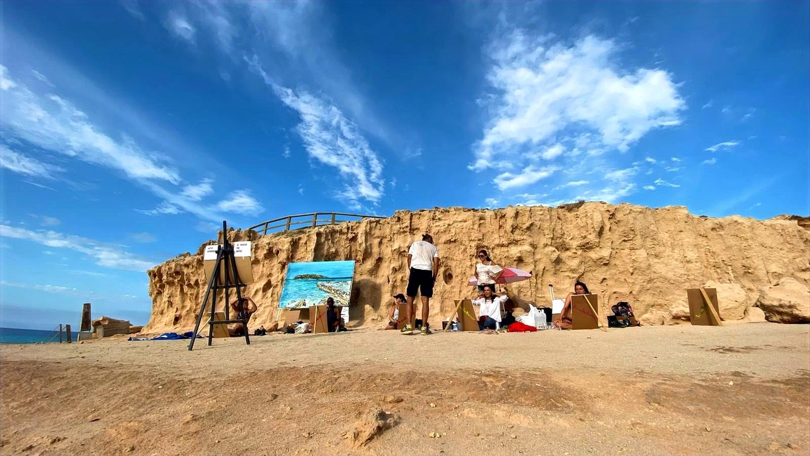 Painting outdoors in Ibiza beneath a rock formation and open sky
